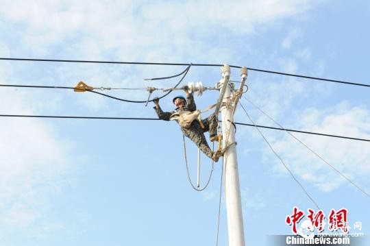 圖為該公司技術(shù)人員正解決農(nóng)村電網(wǎng)低電壓、“卡脖子”等用電難題?！≡櫭?攝