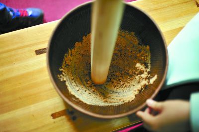 4月16日，桃江縣桃花江竹海景區(qū)，游客使用傳統(tǒng)工具制作的擂茶。